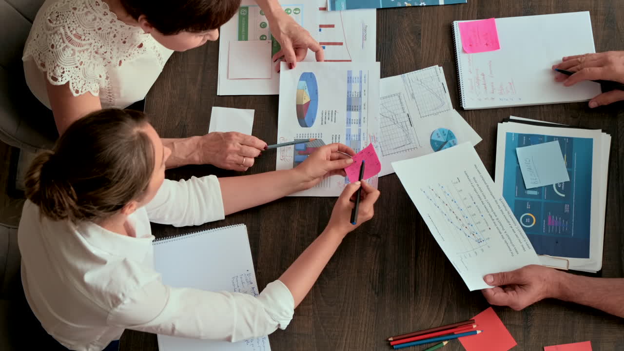 Two coworkers fighting over a graph at a desk in an office
