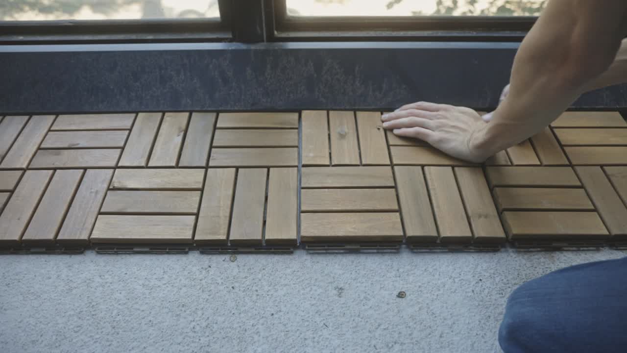 Crop View Of A Person Installing Interlocking Deck Tiles