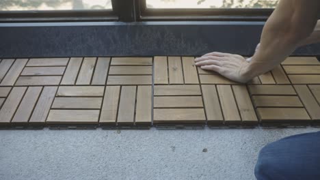 crop view of a person installing interlocking deck tiles