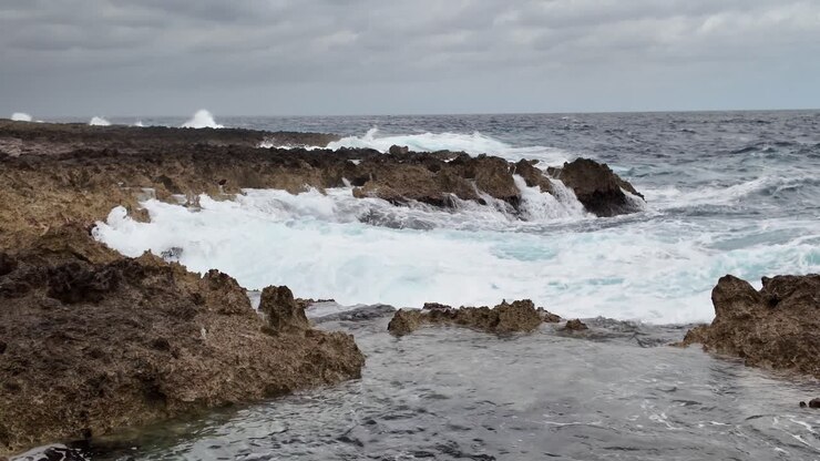 Onde profonde di acqua marina si infrangono sulle rocce