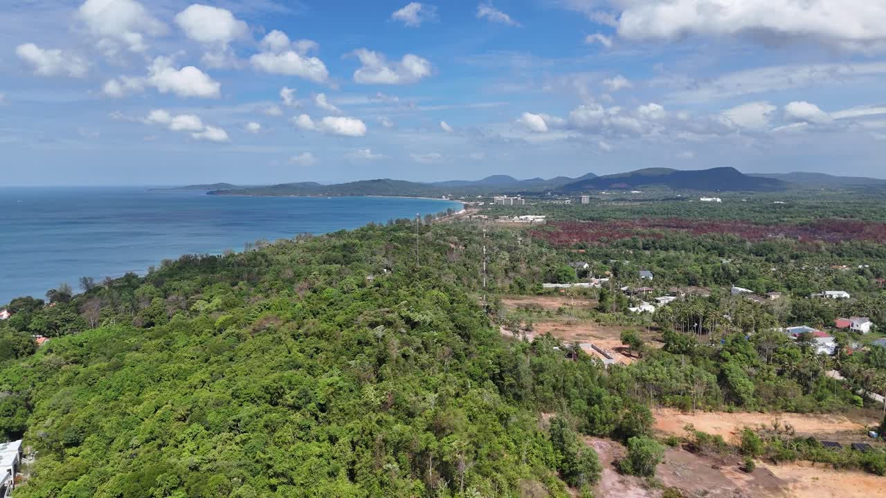 Aerial footage presents a tranquil and relaxing getaway destination, characterized by a pristine expanse of sand, inviting waves, and white buildings with an ideal setting for a peaceful getaway