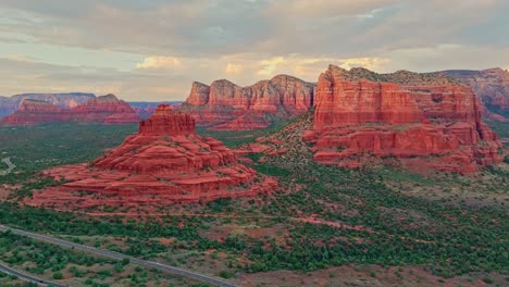 cinematic aerial pullback reveals sweeping round desert butte and sandstone in sedona arizona