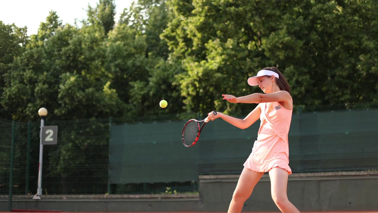 Young Female Athlete Playing Tennis on an Outdoor Court