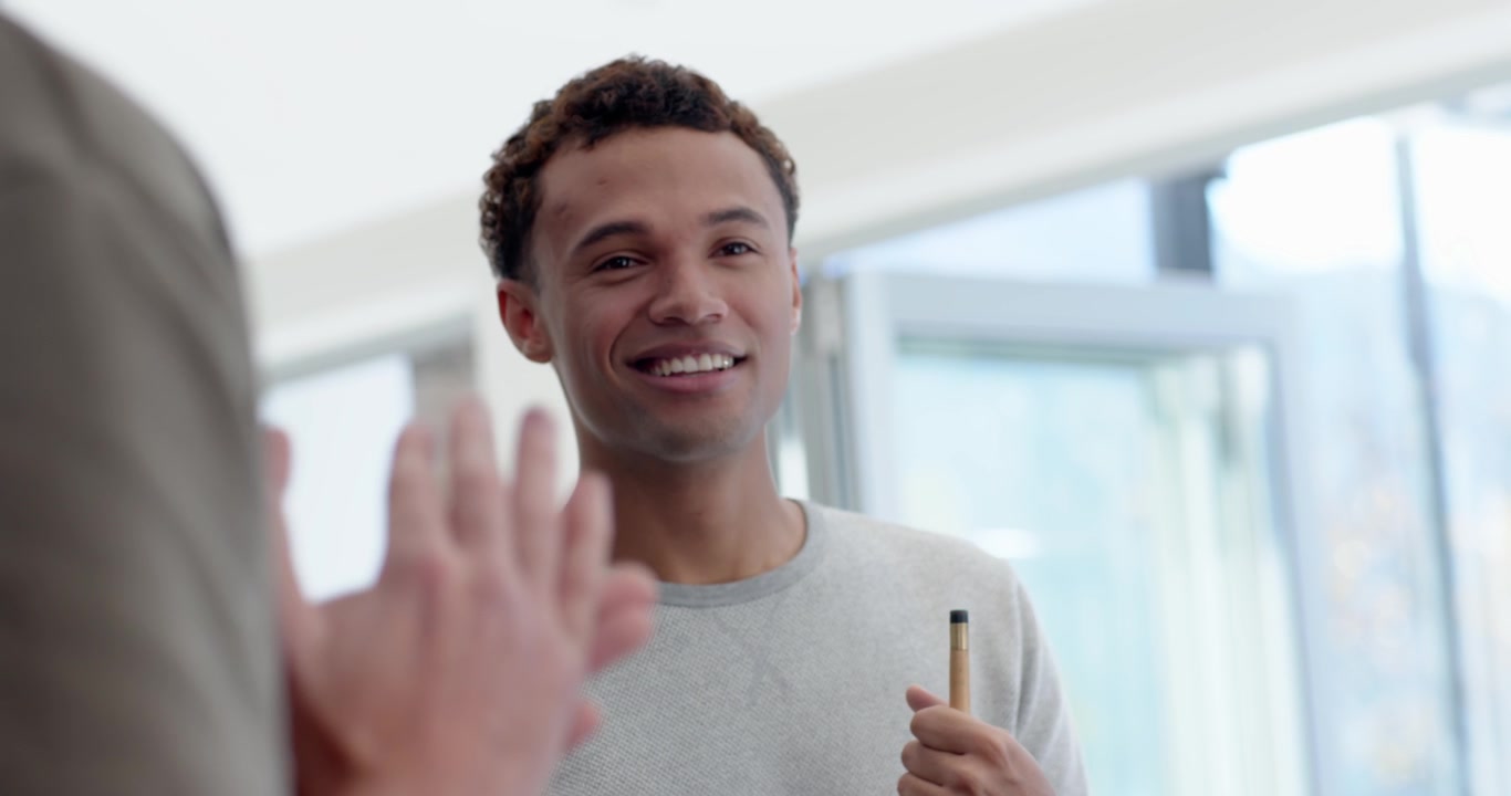 Male friends racking balls with metal rack on pool table, smiling and holding cue preparing game