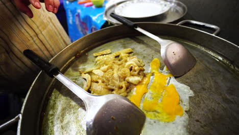 Close-up-shot-of-street-food-in-Thailand-cooked-on-a-griddle-with-chicken-eggs-at-a-food-stall-for-tourists-on-Koh-Phi-Phi