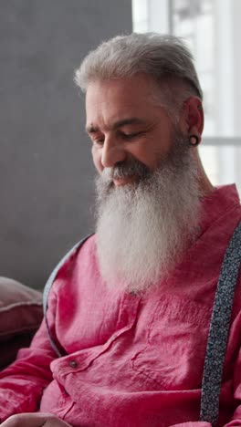 older man with a beard and pink shirt