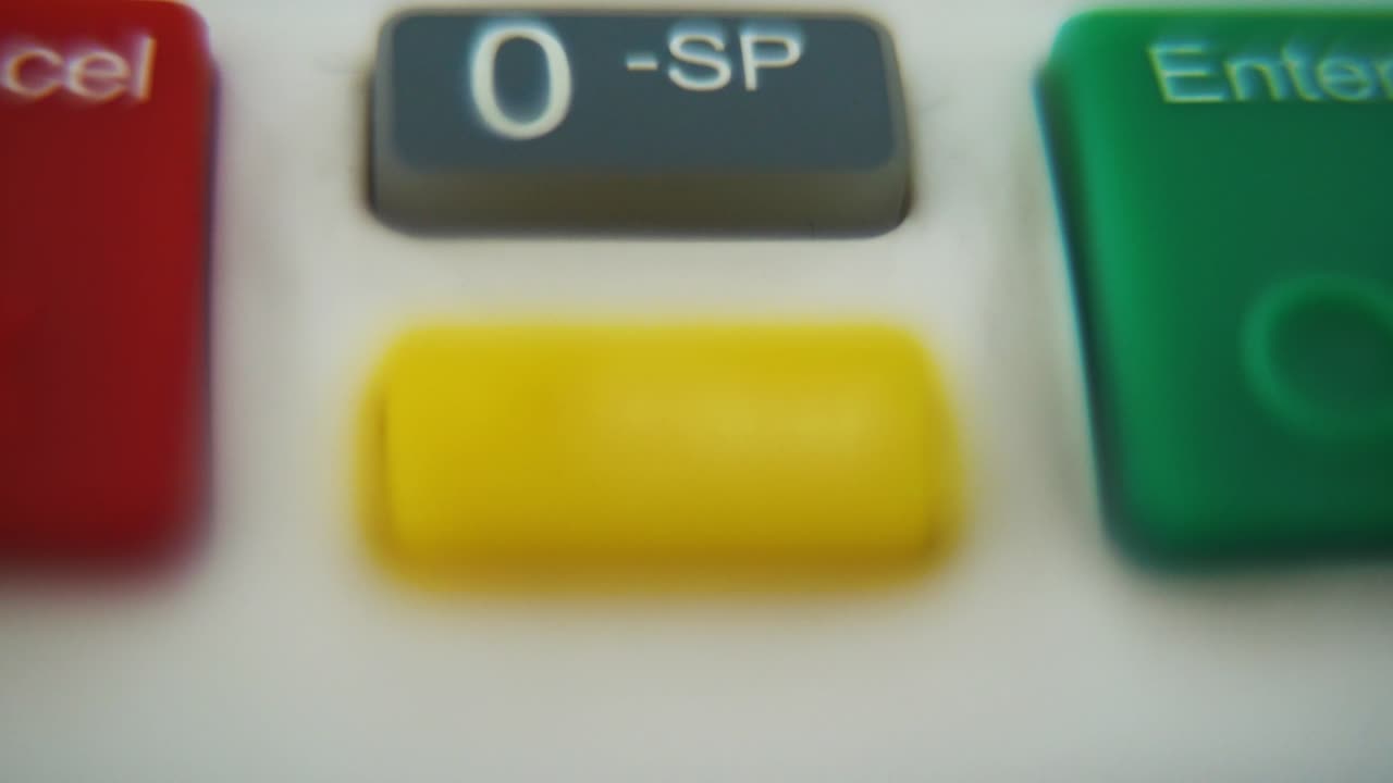 una ripresa macro di un pin pad, numeri e lettere su pulsanti colorati, movimento liscio verso il basso, video full hd, super slow motion, profondità di campo sfocata