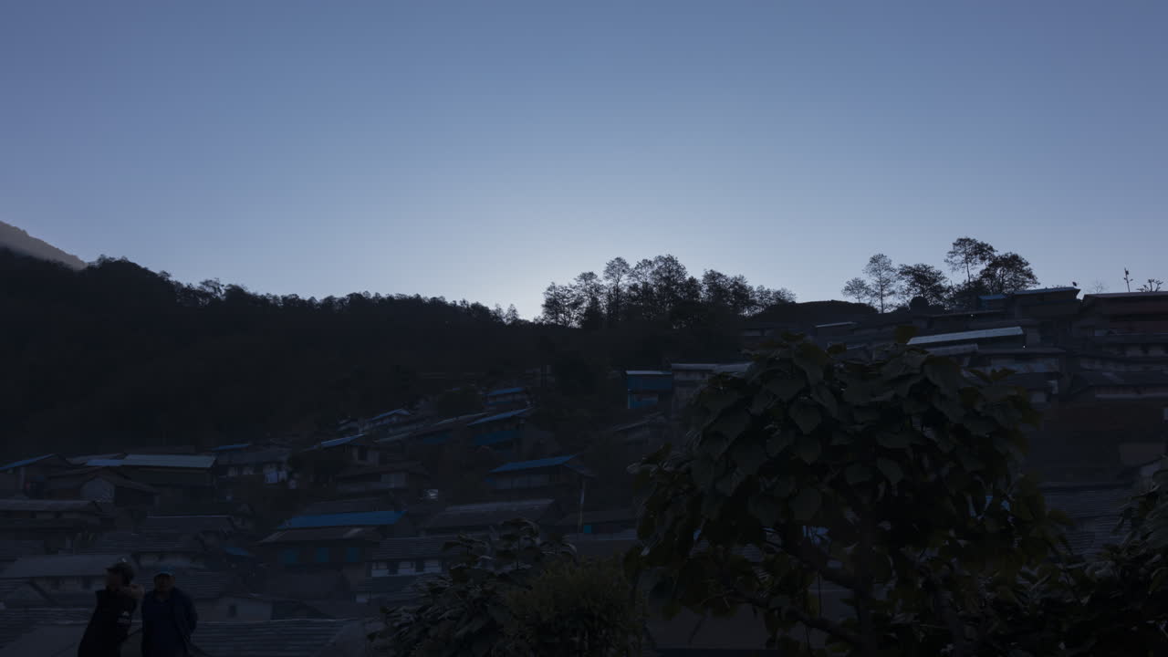 언덕 꼭대기 위로 떠오르는 태양의 아침 저속 촬영 아래 부중 마을을 드러내다