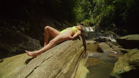 A-bikini-clad-girl-explores-a-cascading-tropical-waterfall-on-a-Caribbean-island