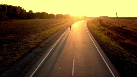 couple running on a country road at sunset