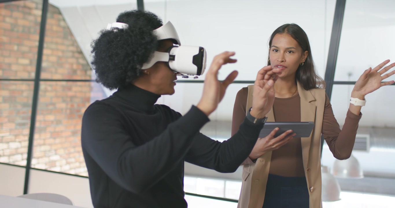 Afroamerikanske kolleger demonstrerer VR efter headset-tilpasning på kontoret, kvinde holder tablet og guider.