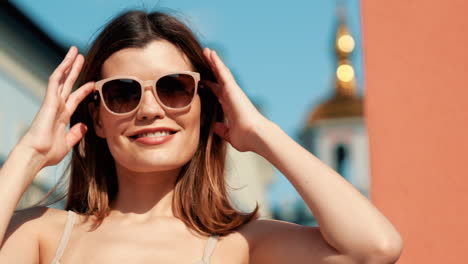 mujer sonriente con gafas de sol al aire libre