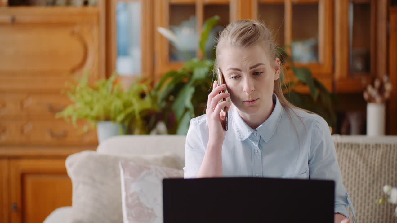 Concetto di ufficio domestico: donna che parla al cellulare e usa il laptop