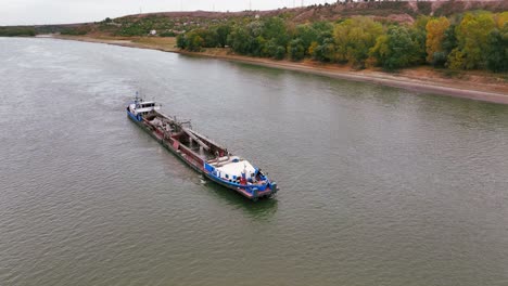 aerial shot of a dredger that glides through a big river, reshaping the landscape