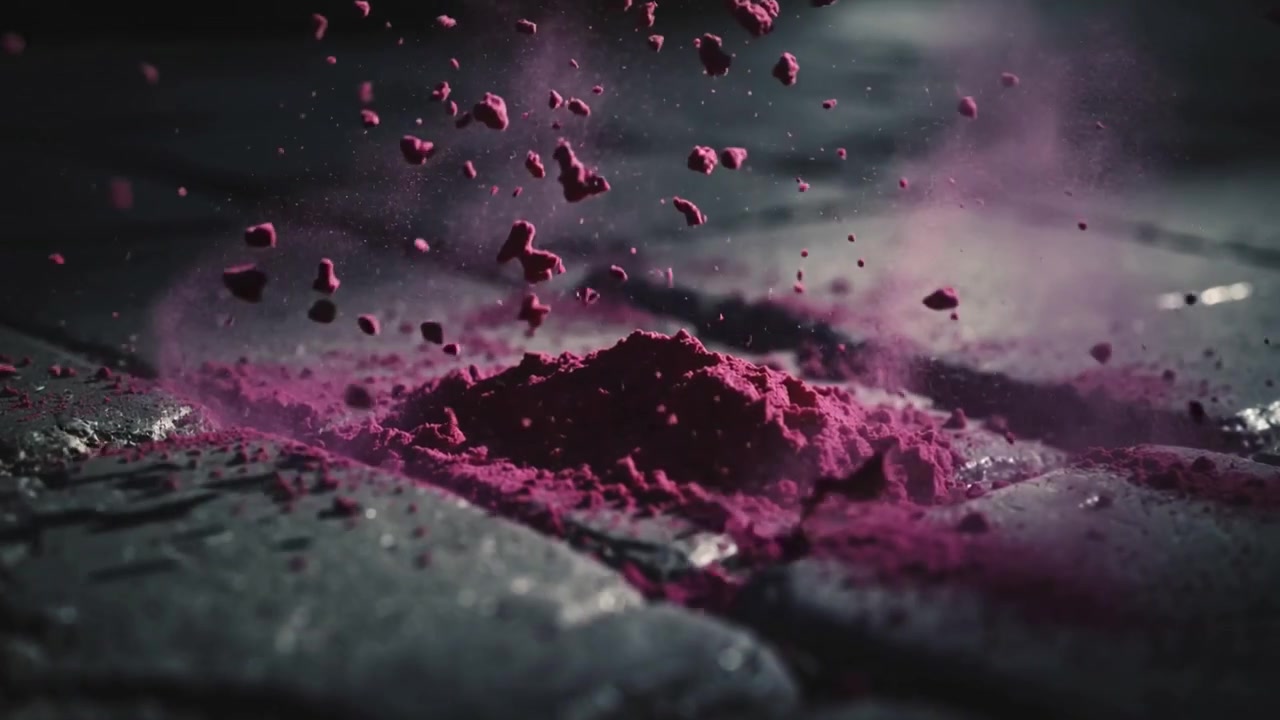 Impressionante massa magenta compatta che si frammenta ed erutta su pavimentazione in pietra, spargendo polvere magenta.