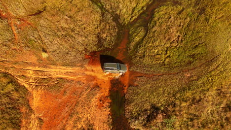 4x4 utility vehicle crosses flooded wetland in national park, top drone view