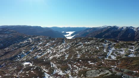 Morning-fog-in-Teigdalen-valley-seen-from-mountain-top-nearby---Beautiful-forward-moving-aerial-from-tall-summit-during-sunny-autumn-morning---Forward-moving-aerial-Nesheim-mountain-Evanger-Norway