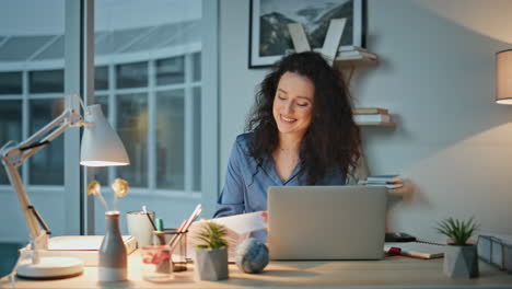 smiling woman reading documents in modern office. professional reviewing papers