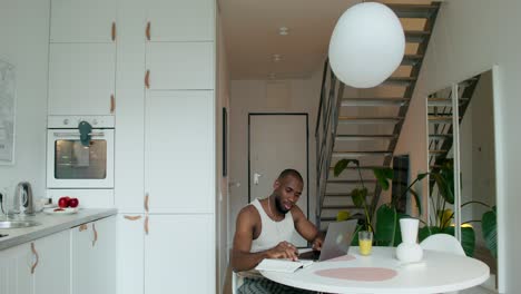 hombre trabajando desde casa en una cocina moderna