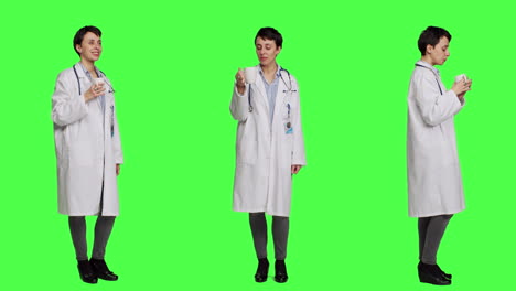 woman physician drinking a cup of coffee against greenscreen backdrop