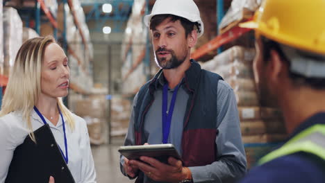 warehouse workers discussing inventory with a tablet