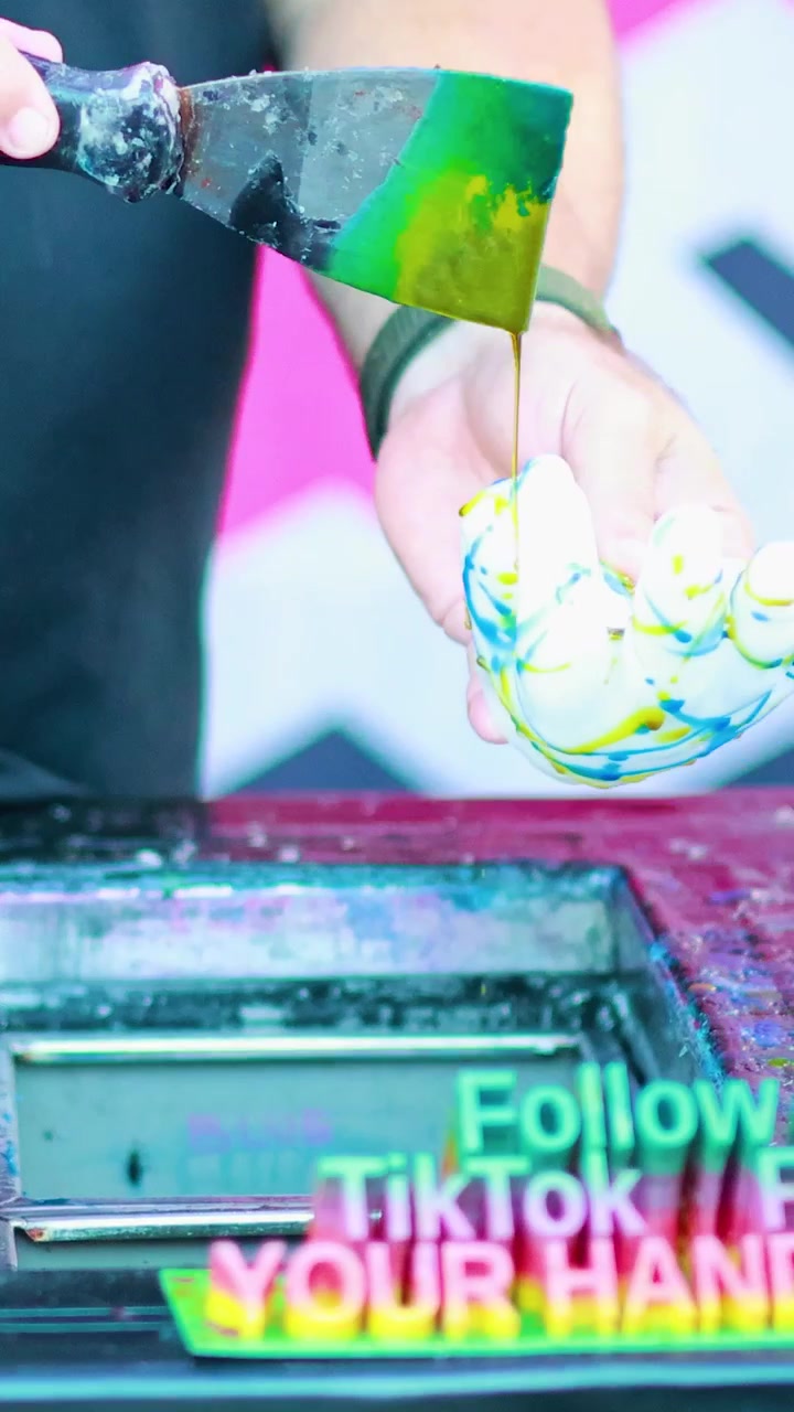 活気ある環境で、カラフルな絵の具を使って作られた鮮やかなワックスの手が、芸術的な創造性と職人技を際立たせている。
