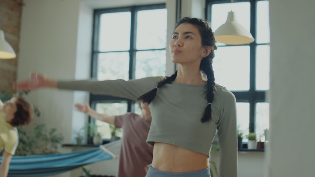 Asian Woman Doing Side Stretch on Yoga Class