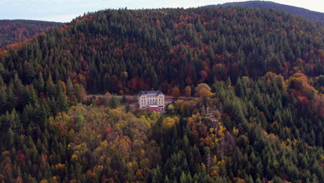 revealing aerial view of the eventhaus wiedenfelsen located in the black forest near bühlertal on a colorfful autum day.