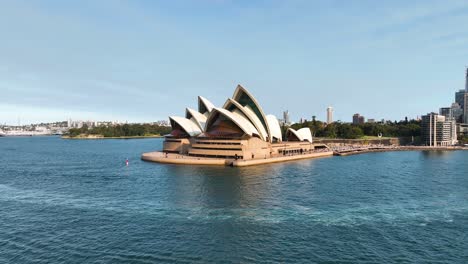 Toma-Aérea-De-Aproximación-De-La-ópera-De-Sydney,-Panorámica-Para-Revelar-Rascacielos-En-Sydney-CBD,-Australia