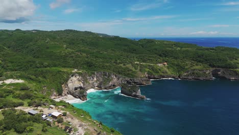 aerial drone establishing dolly of manta bay vibrant blue water and dramatic cliffs on nusa penida, bali