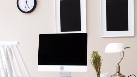 computer, table lamp and cup of tea on table