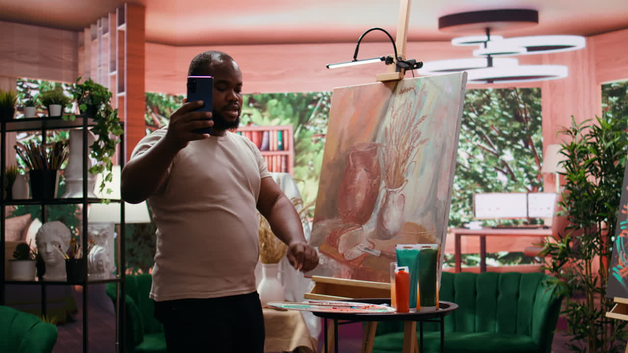 Man in Art Studio Takes Pictures of Painting