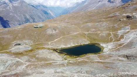 Drone-flight-over-the-deep-green-Riffelsee-near-Zermatt-in-Switzerland