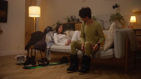 couple getting ready for a snowboarding trip at home
