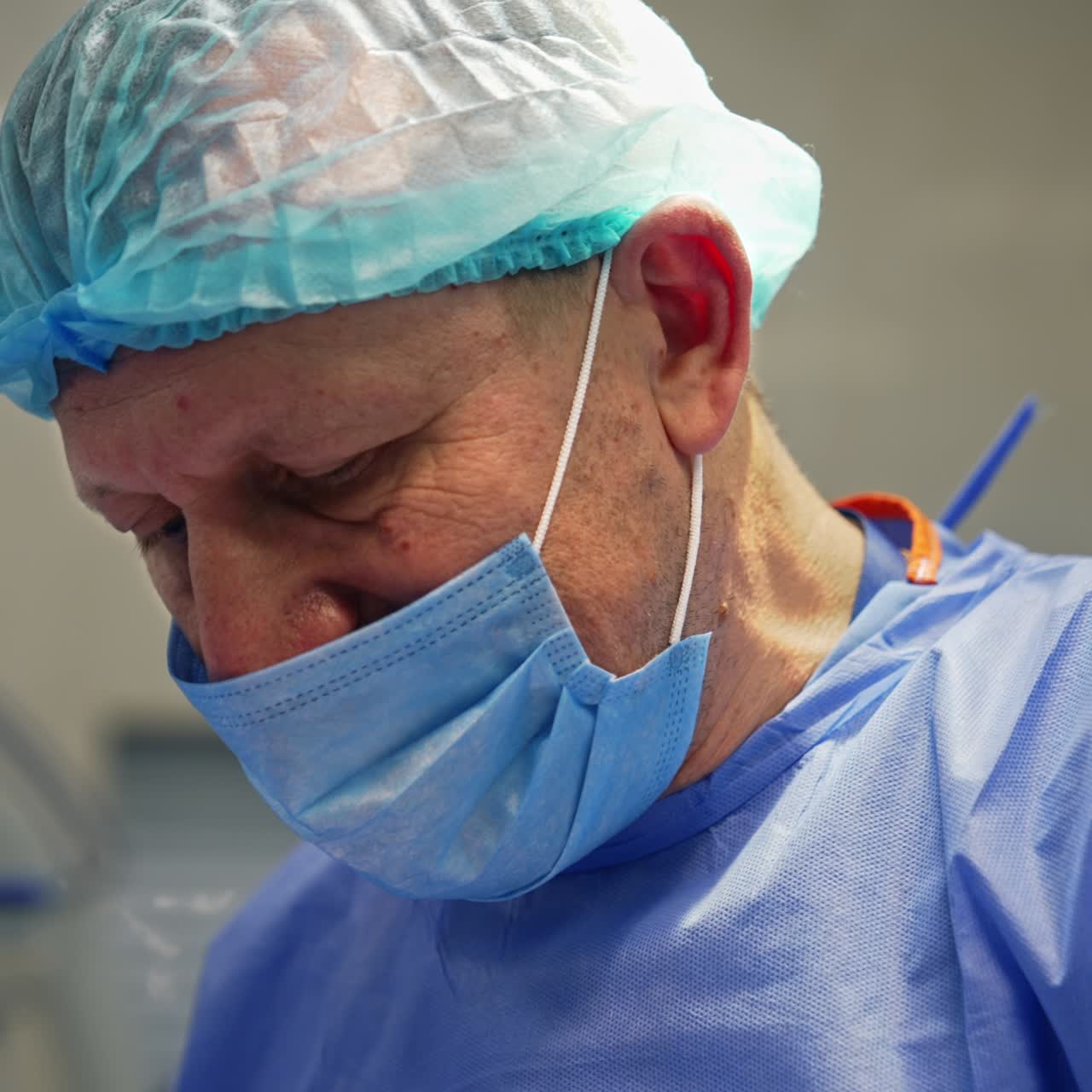 Aged medical professional doing surgical procedure in operational room. Confident calm focused doctor portrait close up