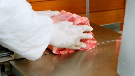 butcher cutting meat on meat cutting machine in shop 4k