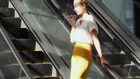 joven mujer de negocios en una escalera mecánica en un edificio moderno