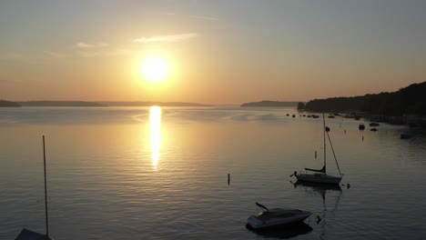 Glassy-lake-water-of-Lake-Geneva,-Wisconsin-during-golden-hour-from-a-aerial-view