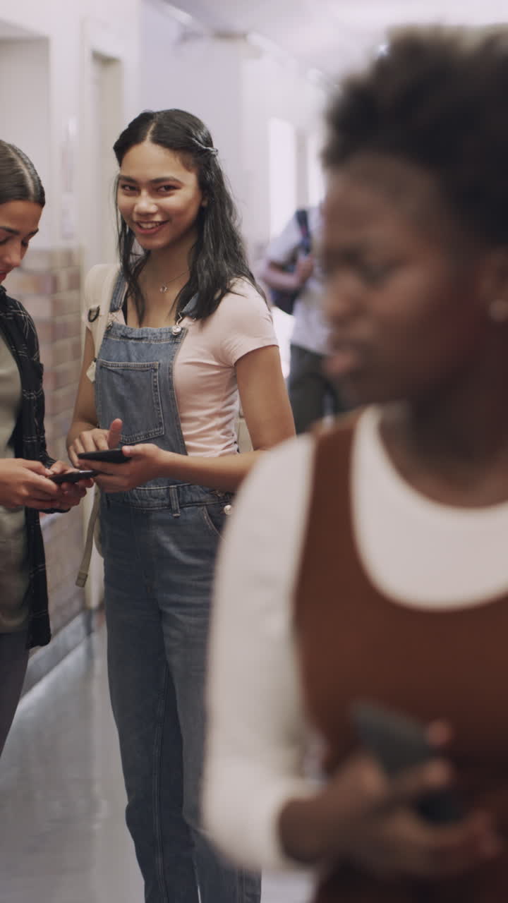 Diverse Teenagers Socializing and Using Smartphones in School Hallway