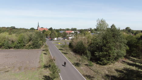 man walking into local village down country road, aerial view