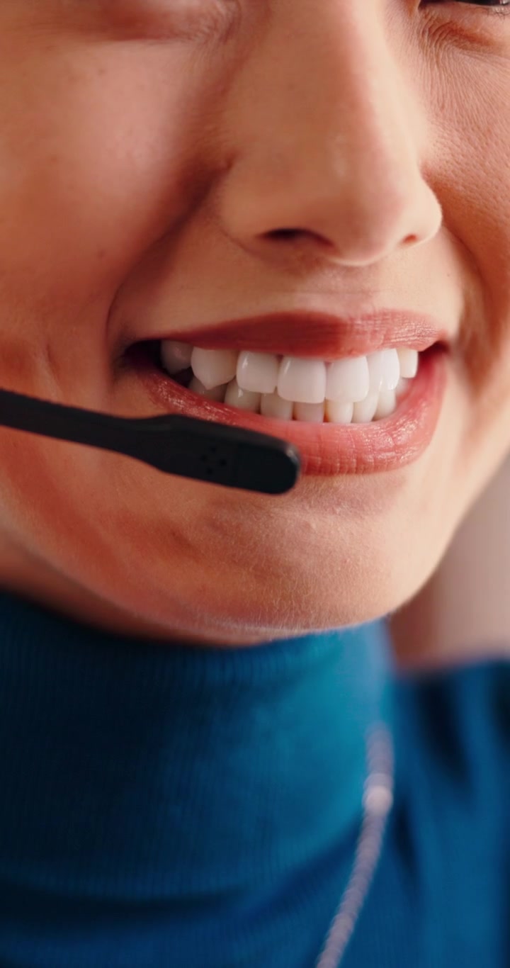 Primo piano di un operatore del servizio clienti sorridente mentre indossa un auricolare