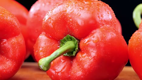 fresh red peppers on wooden chopping board, extreme close-up