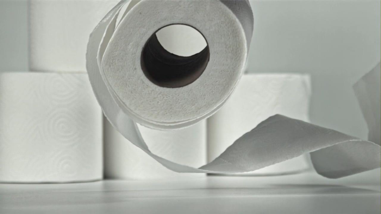 White Toilet Paper Roll Falling and Unwinding in Slow Motion