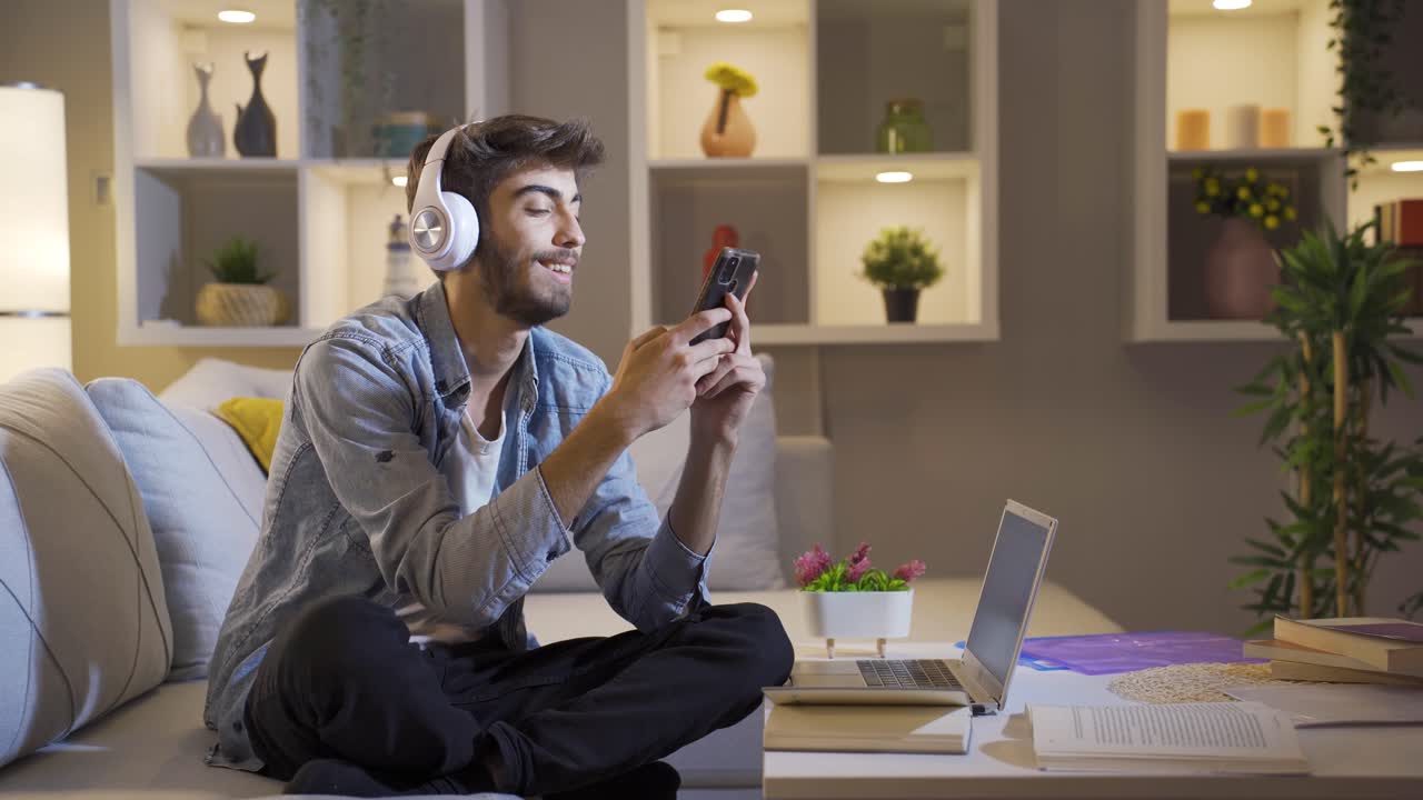 hombre escuchando música en el sofá por la noche. disfrutado y feliz.