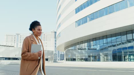 businesswoman walking towards modern building