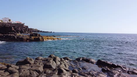 view at coastal town, endless ocean surface surrounding rocky shore