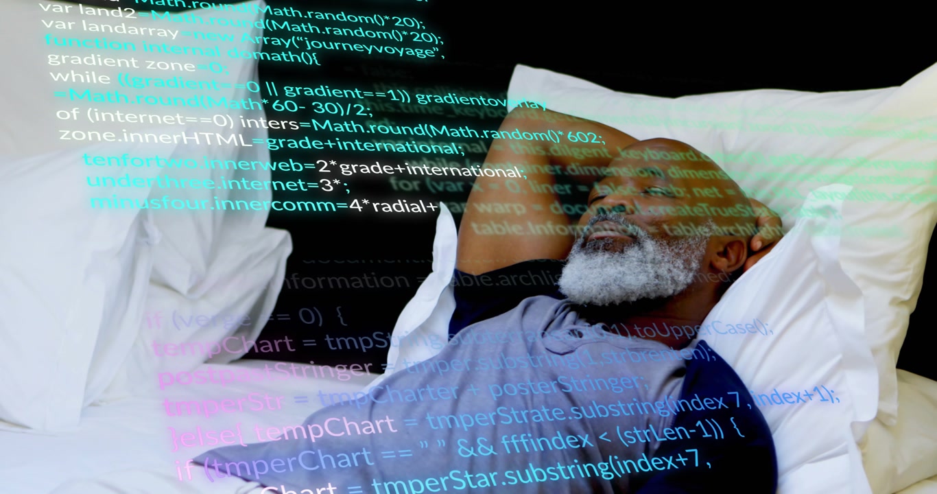 mature man lying in bed initiating code streams overlaying face and pillows and studying software