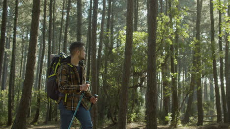 young sporty male tourist hiking with backpack