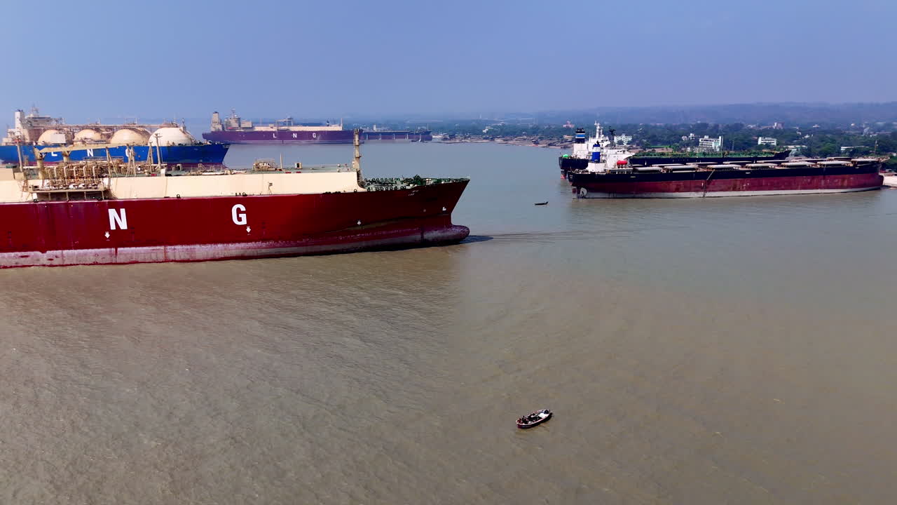 Cinematic aerial panning shot of large cargo ships abandoned in a ship graveyard in Bangladesh