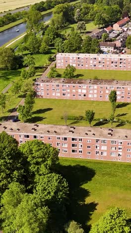 aerial view of residential apartment buildings with green lawns and canal